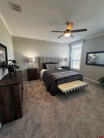 a bedroom with bed lamp and window