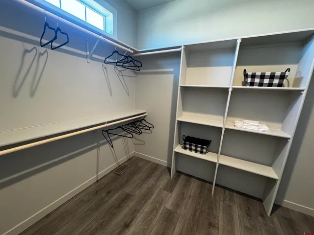 a view of walk in closet with clothes and shoes