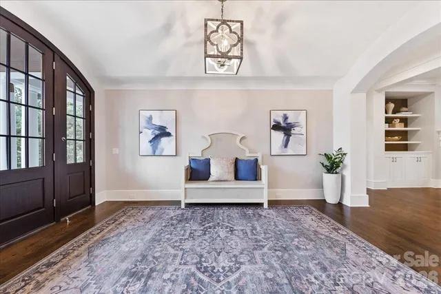 a view of a dining room with furniture a chandelier and wooden floor