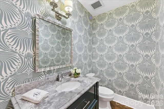 a bathroom with a sink a toilet and shower a mirror