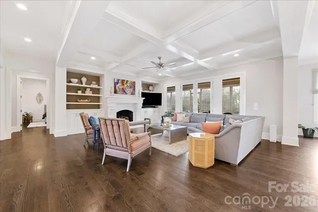 a living room with furniture kitchen view and a large window