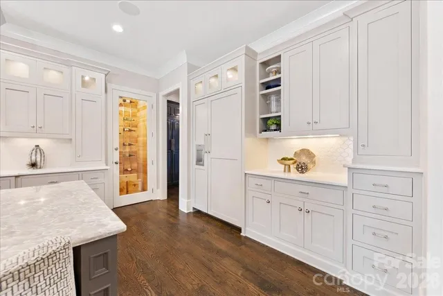 a kitchen with white cabinets and appliances