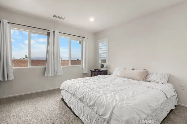 a bedroom with a large bed and a large window