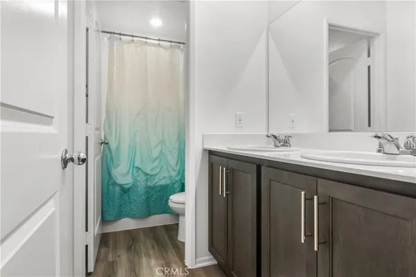 a bathroom with a double vanity sink mirror and toilet