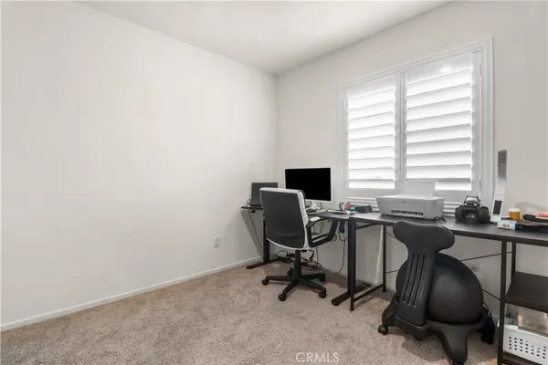 a view of a workspace with furniture and a window