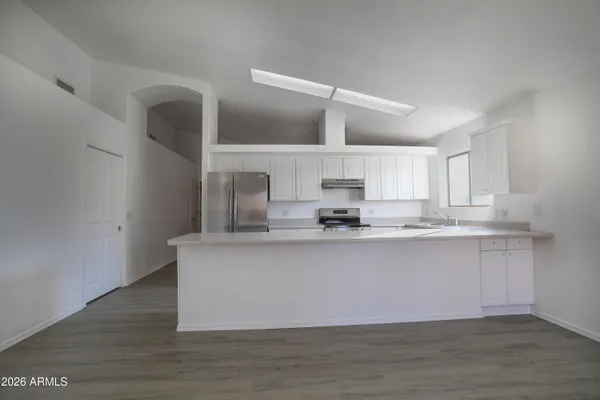 a large white kitchen with wooden floor