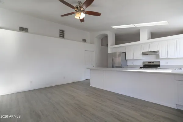 a kitchen with stainless steel appliances a wooden floor and window