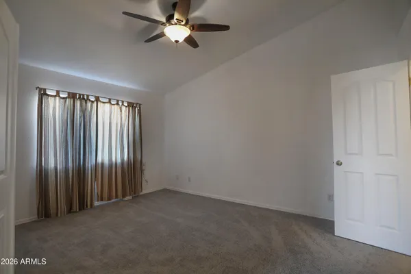 an empty room with a window and a fan