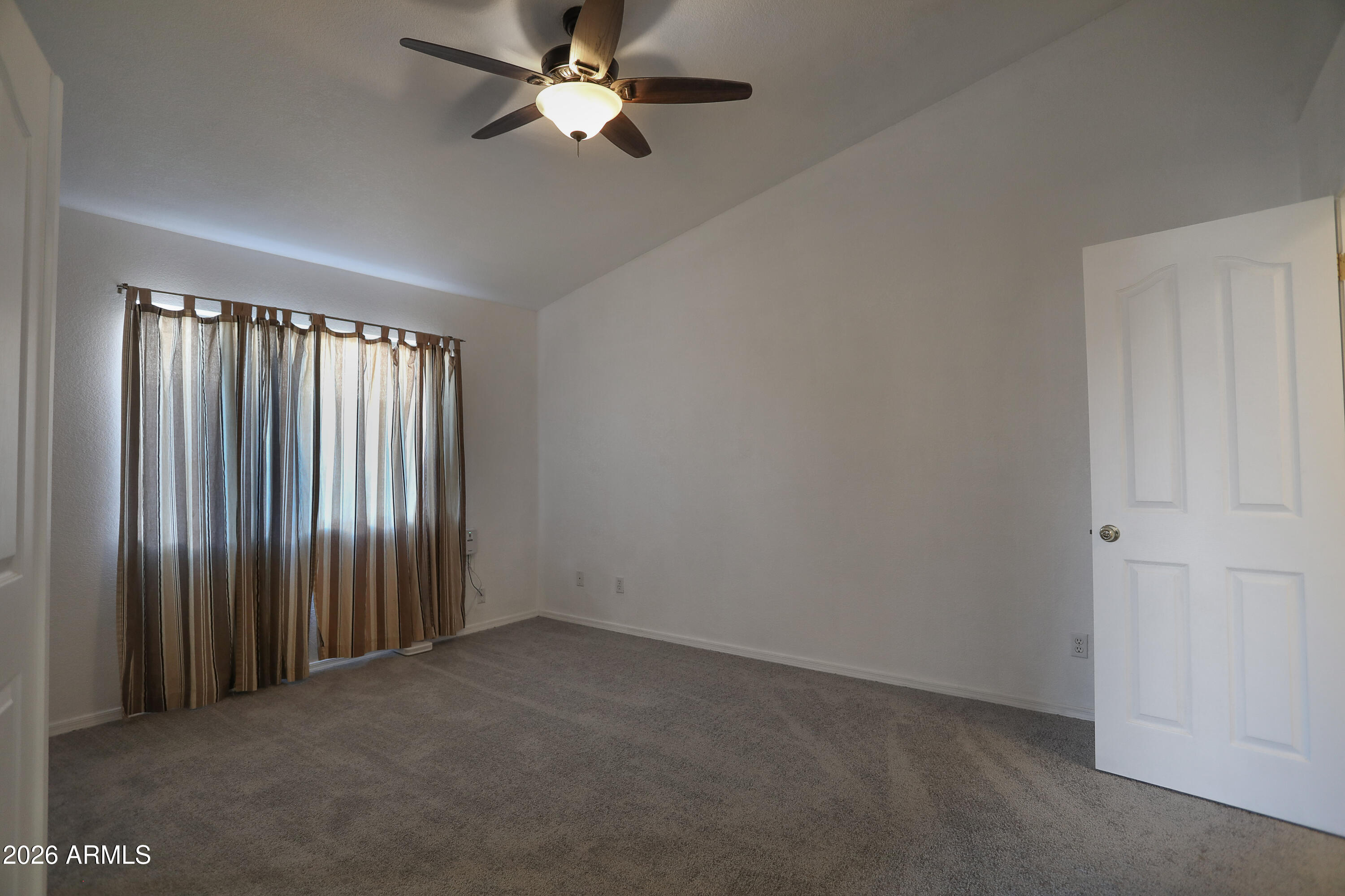 762 West 17th Avenue Apache Junction, AZ 85120 - Photo 8 of 19 an empty room with a window and a fan
