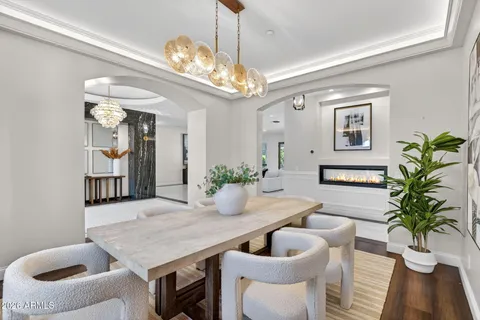 a living room with furniture kitchen view and a wooden floor