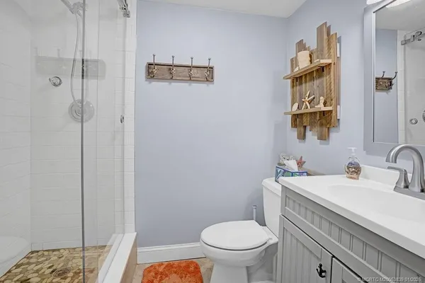 a bathroom with a sink a toilet and shower