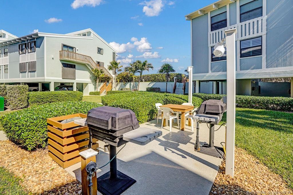 2355 Northeast Ocean Boulevard, Unit 39B Stuart, FL 34996 - Photo 18 of 22 a view of a patio with table and chairs potted plants and a large tree