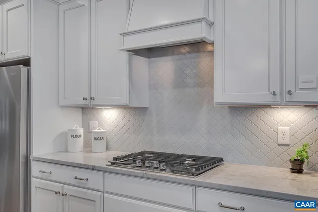 a kitchen with white cabinets and a stove