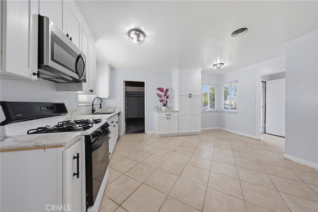 5653 Corwin Lane Riverside, CA 92503 - Photo 5 of 14 a kitchen with stainless steel appliances granite countertop a stove a sink and a refrigerator