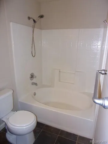 a white bath tub sitting next to a white toilet and a shower