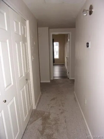 a view of a hallway with wooden floor and a cabinet