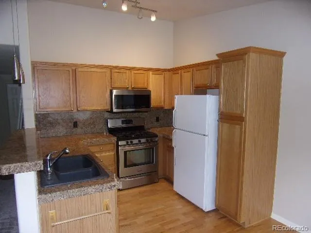 a kitchen with stainless steel appliances granite countertop a refrigerator stove and microwave