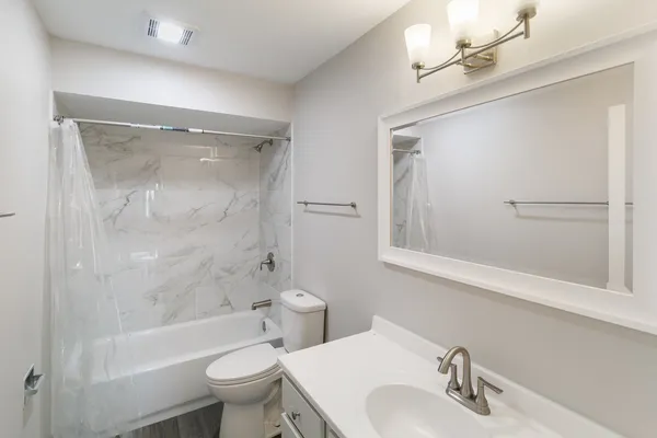 a bathroom with a sink toilet and shower