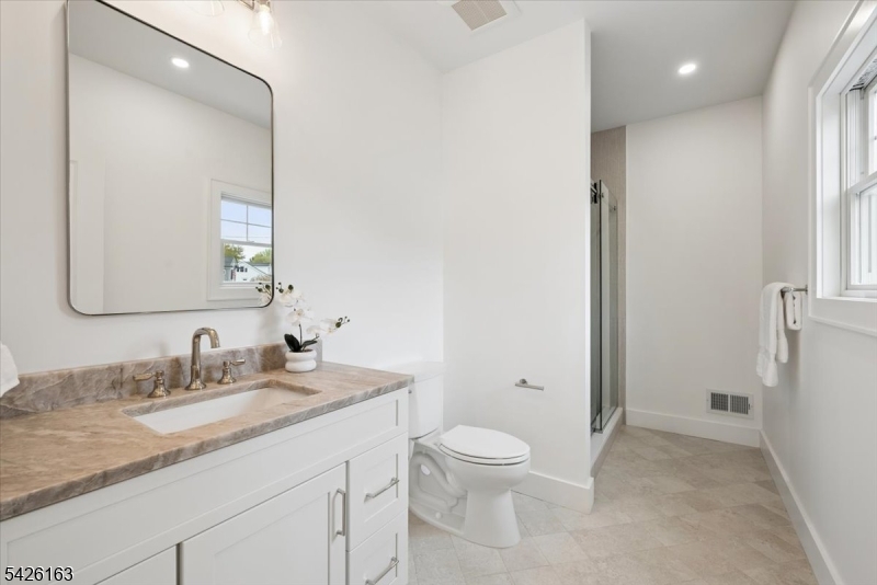 34 Crestview Avenue Madison, NJ 07940 - Photo 20 of 43 a bathroom with a granite countertop sink a toilet and a mirror