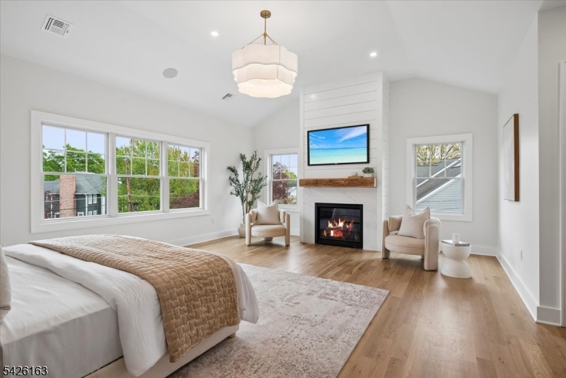 34 Crestview Avenue Madison, NJ 07940 - Photo 22 of 43 a spacious bedroom with a large bed a fireplace and windows
