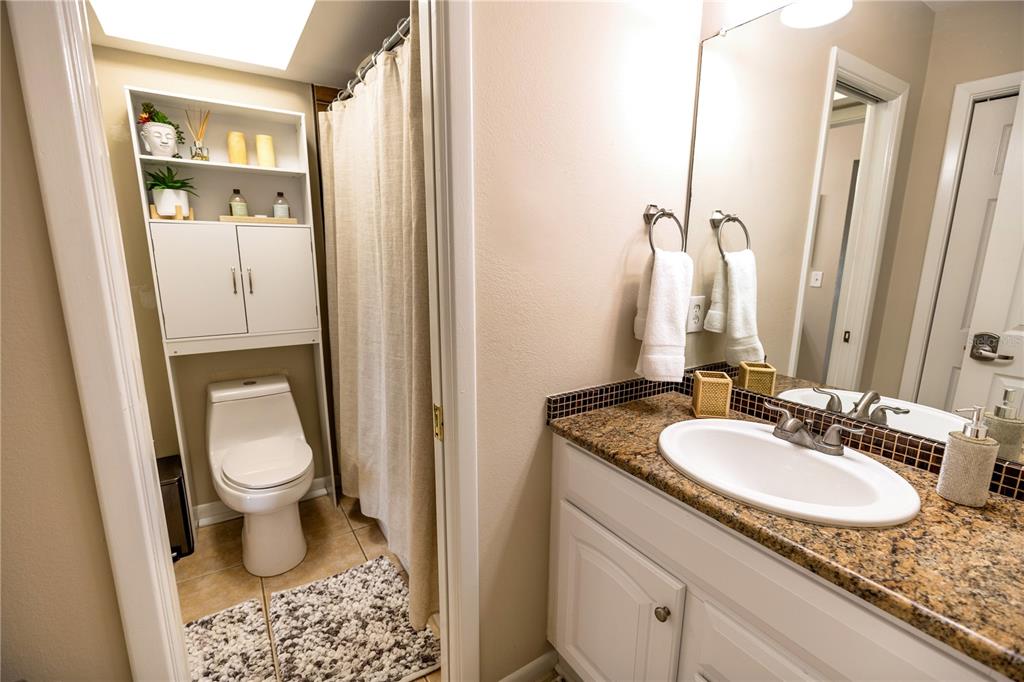 6504 Abaco Drive, Unit 101 Apollo Beach, FL 33572 - Photo 21 of 34 a bathroom with a granite countertop sink and a mirror