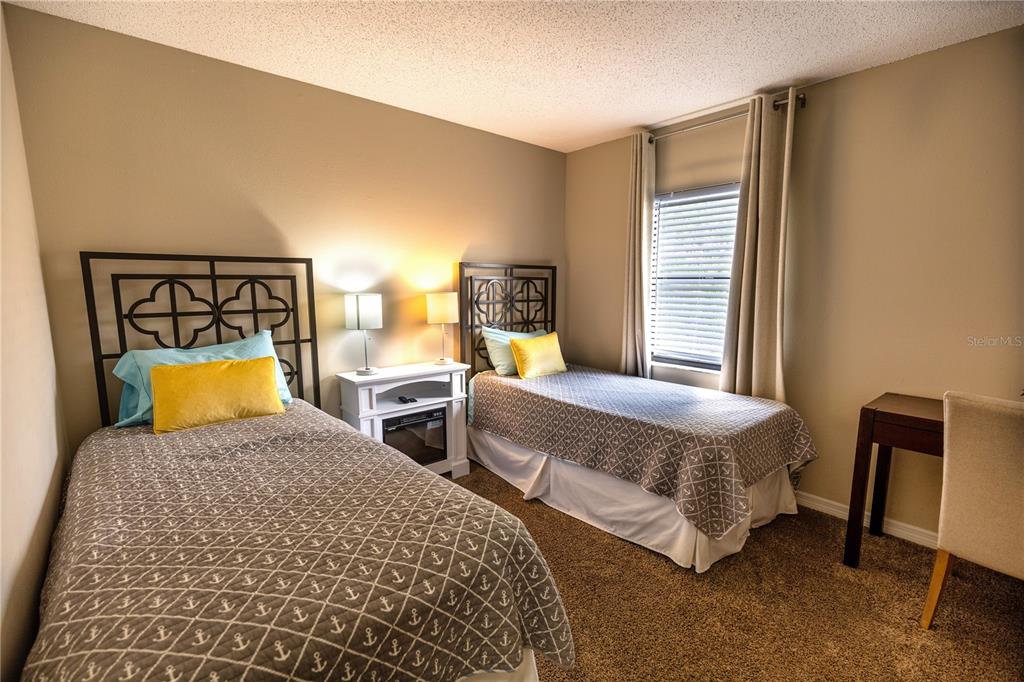 6504 Abaco Drive, Unit 101 Apollo Beach, FL 33572 - Photo 23 of 34 a bedroom with two beds and a lamp