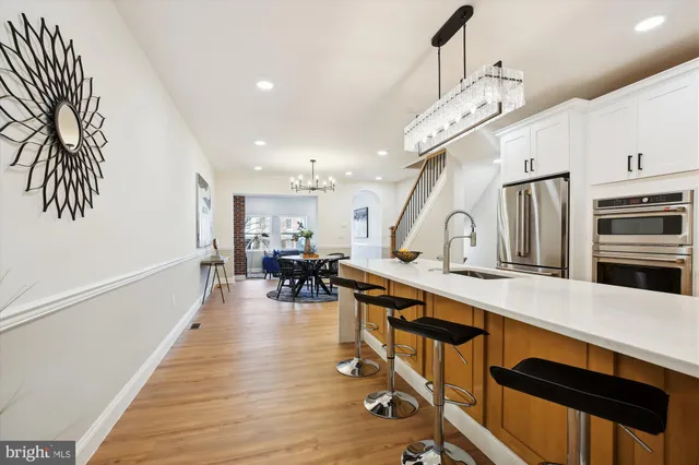 a kitchen with granite countertop a refrigerator and a stove top oven
