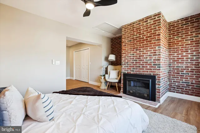 a large bedroom with a bed and large mirror with wooden floor