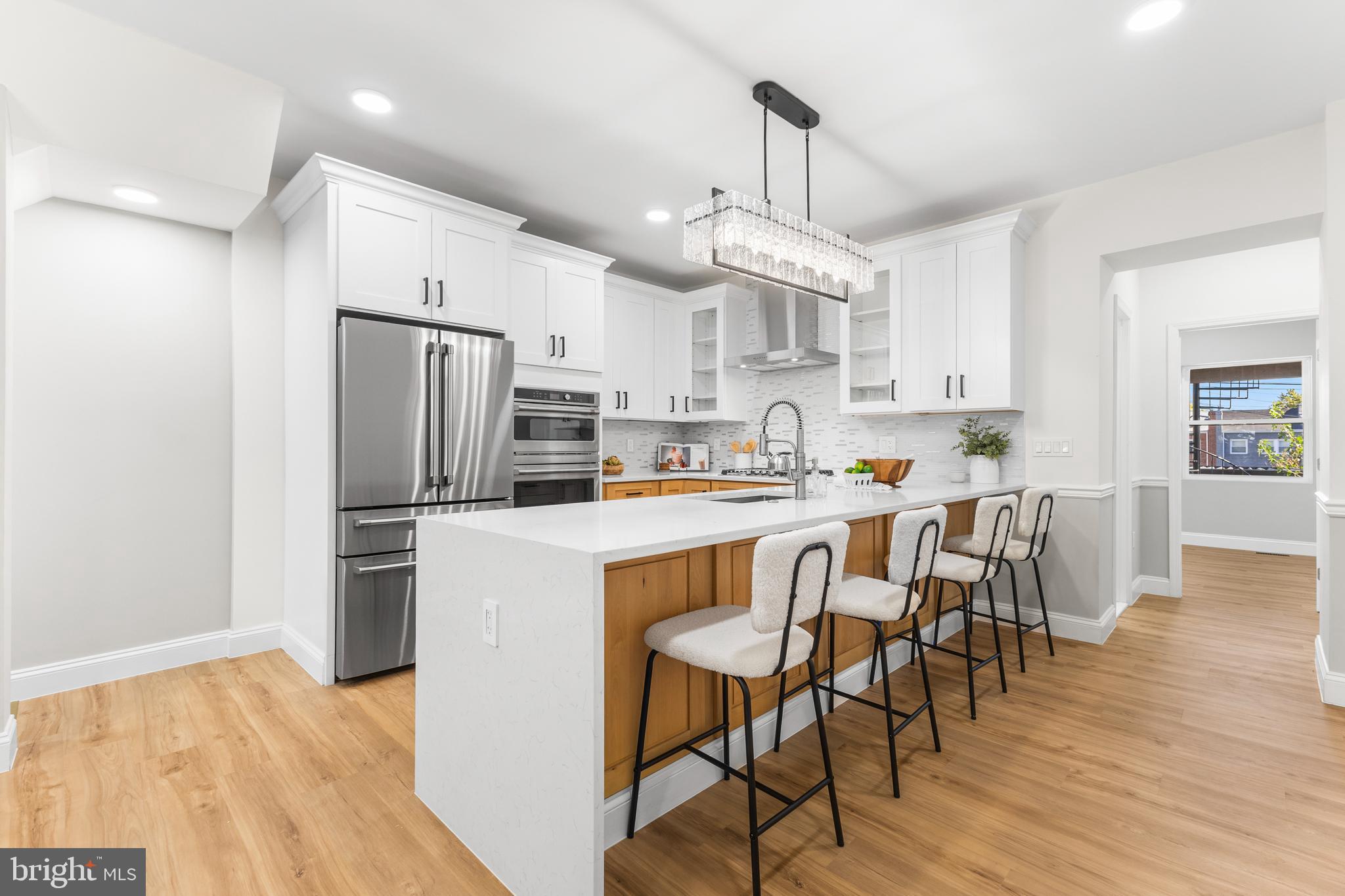 329 15th Street Northeast Washington, DC 20002 - Photo 7 of 71 a kitchen with stainless steel appliances a dining table chairs refrigerator and microwave