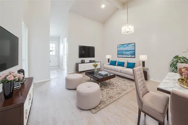 a living room with furniture a flat screen tv and kitchen view