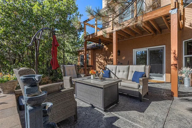 a view of a patio with couches and a dining table and chairs with wooden floor and fence