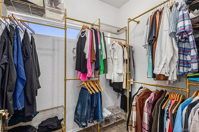 a view of walk in closet with clothes