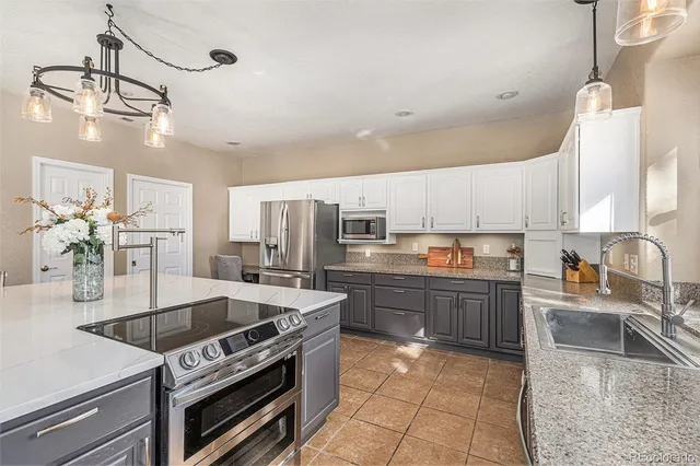a kitchen with stainless steel appliances granite countertop a sink a stove and a refrigerator