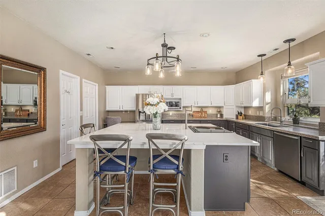 a kitchen with a dining table chairs sink and cabinets