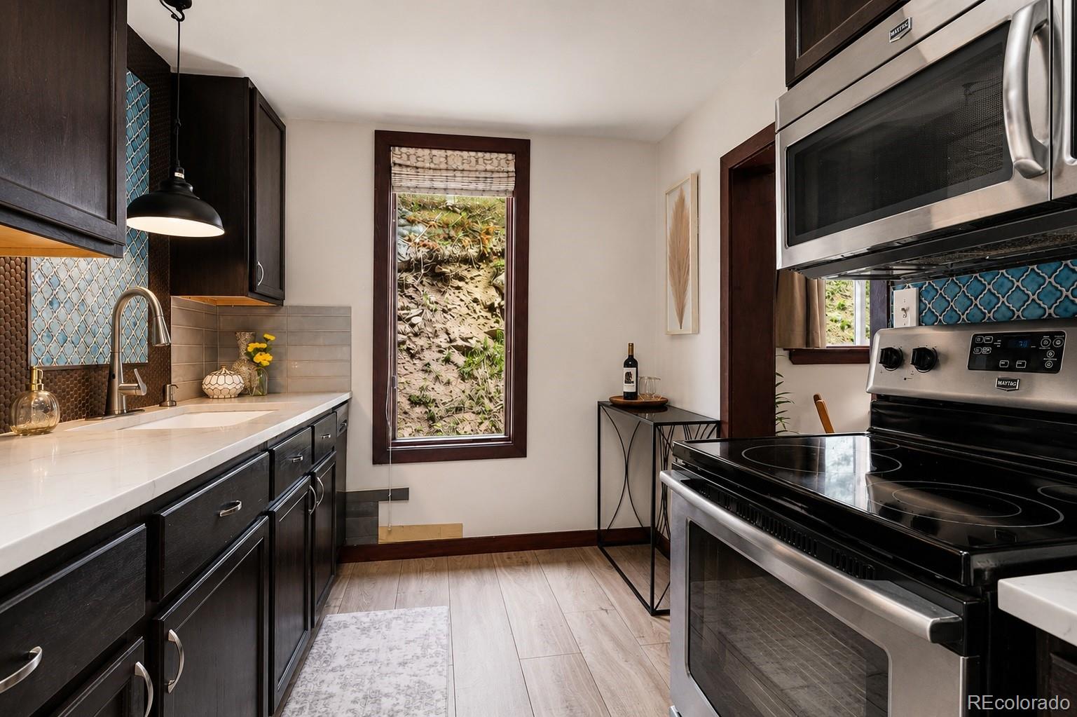 7520 South Blue Creek Road Evergreen, CO 80439 - Photo 6 of 22 a kitchen with a stove and a microwave