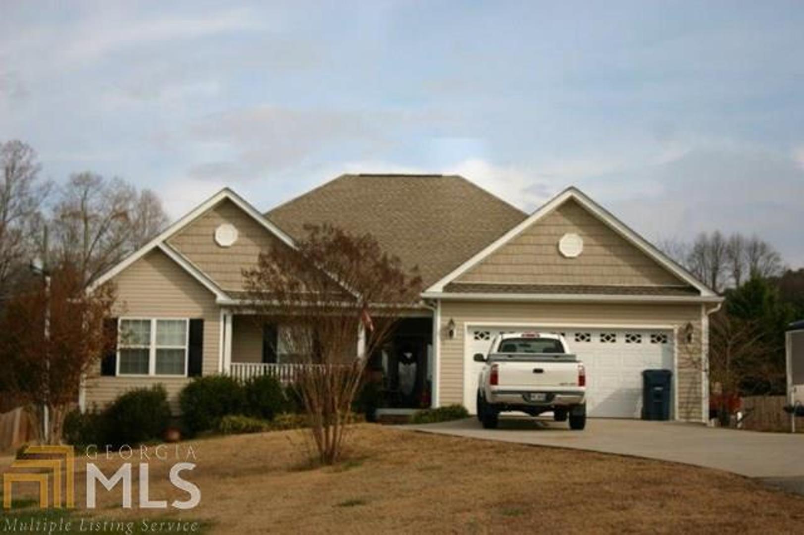 a front view of a house with a garden and parking space