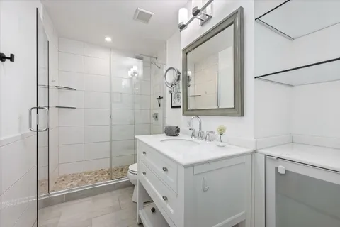 a bathroom with a double vanity sink mirror and shower