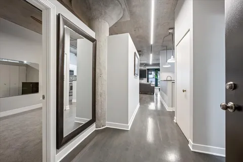 a view of a hallway with wooden floor and staircase