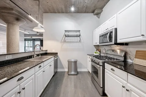 a kitchen with stainless steel appliances granite countertop a stove and a sink