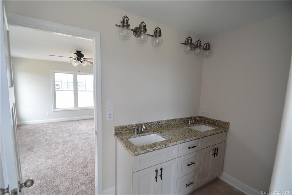 1311 George Brown Road Crouse, NC 28033 - Photo 21 of 32 a bathroom with a granite countertop sink and white cabinets