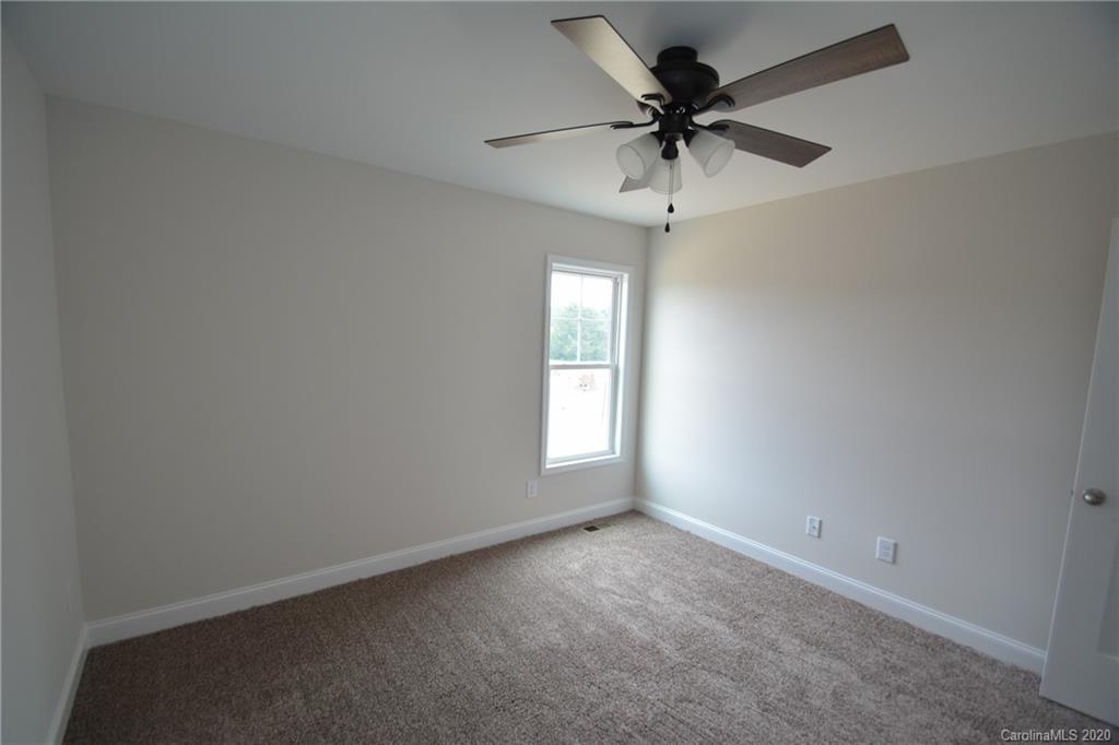1311 George Brown Road Crouse, NC 28033 - Photo 27 of 32 an empty room with a chandelier fan and windows