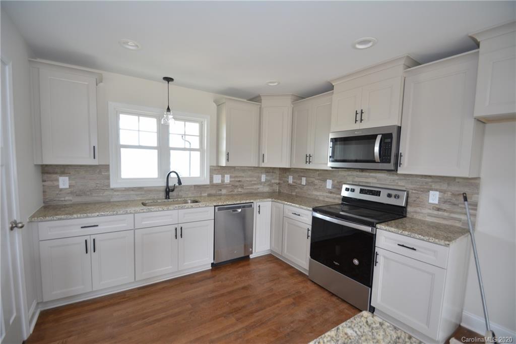 1311 George Brown Road Crouse, NC 28033 - Photo 4 of 32 a kitchen with granite countertop white cabinets and white appliances