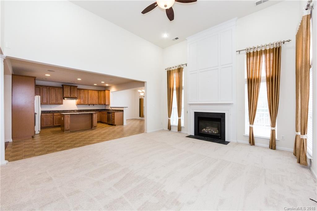 7810 Greylock Ridge Road Matthews, NC 28105 - Photo 11 of 31 an empty room with windows and a fireplace