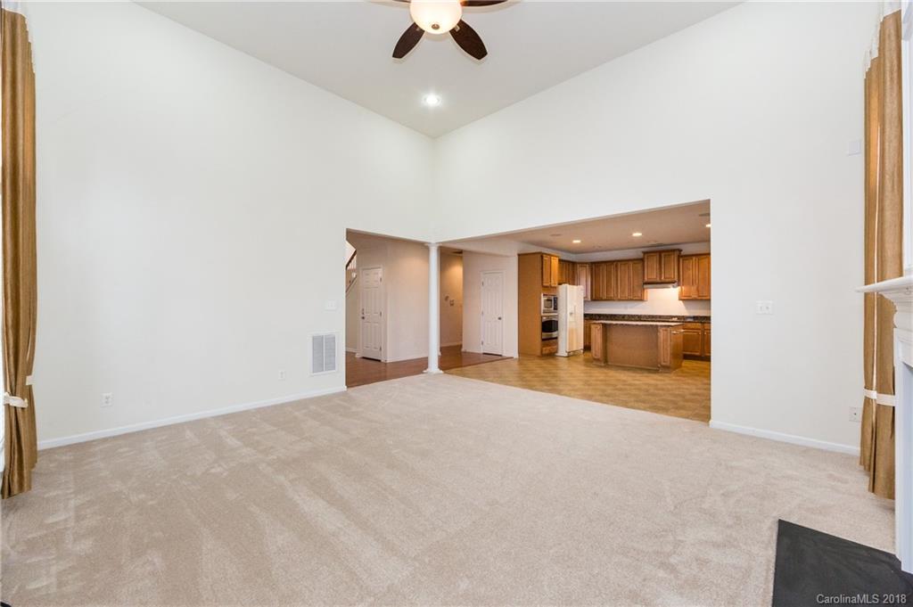 7810 Greylock Ridge Road Matthews, NC 28105 - Photo 12 of 31 an empty room with chandelier fan and windows