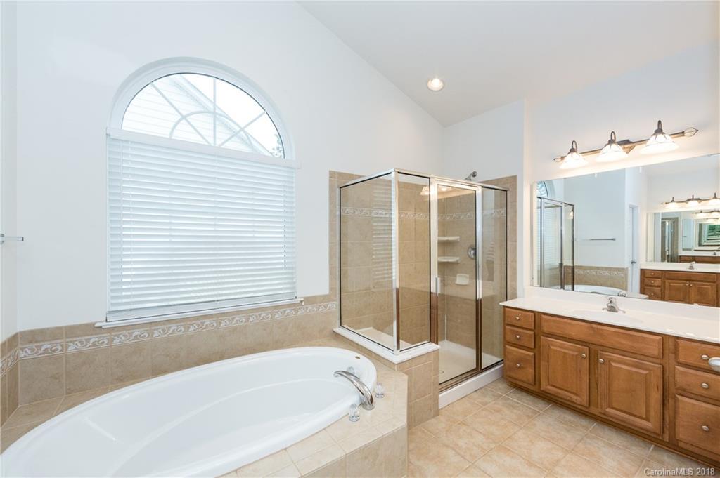 7810 Greylock Ridge Road Matthews, NC 28105 - Photo 22 of 31 a bathroom with a tub sink and mirror