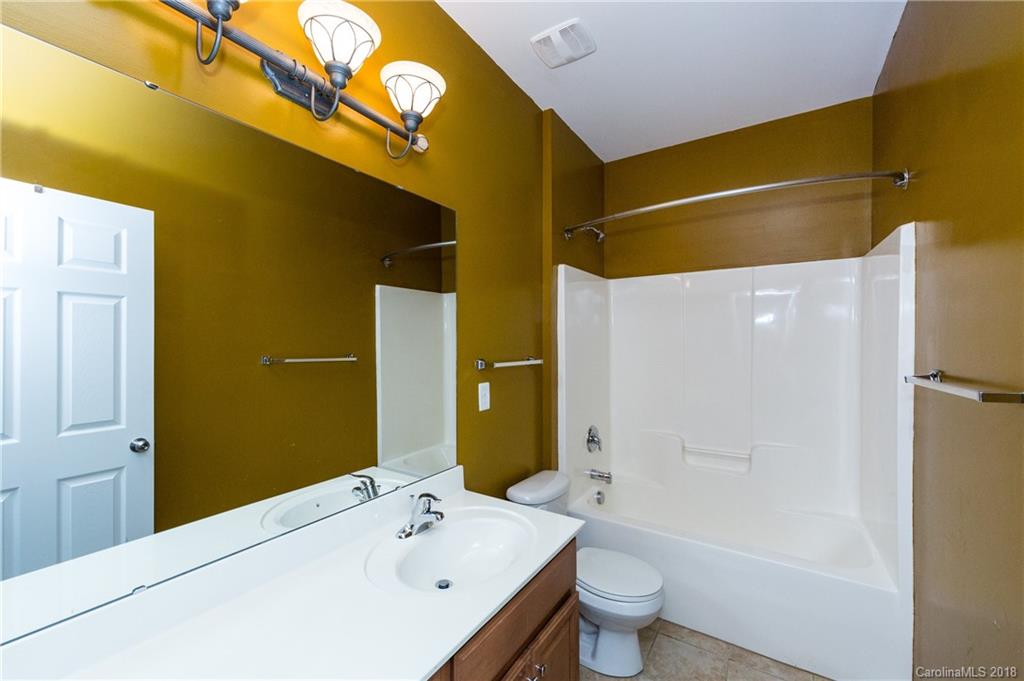 7810 Greylock Ridge Road Matthews, NC 28105 - Photo 25 of 31 a bathroom with a granite countertop sink a toilet and shower