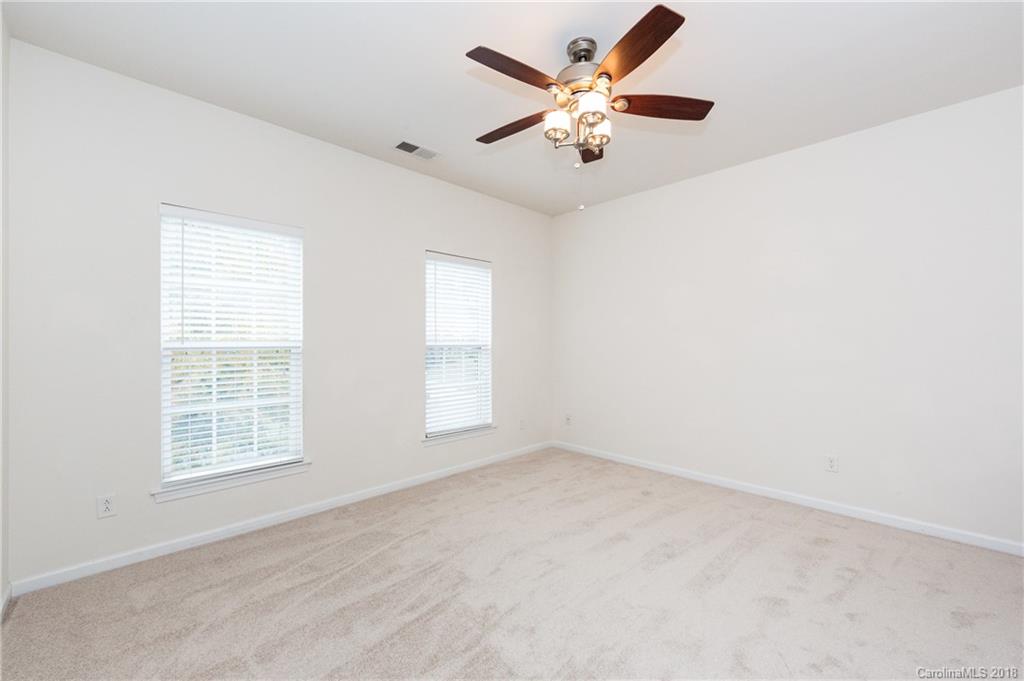 7810 Greylock Ridge Road Matthews, NC 28105 - Photo 27 of 31 an empty room with chandelier fan and windows