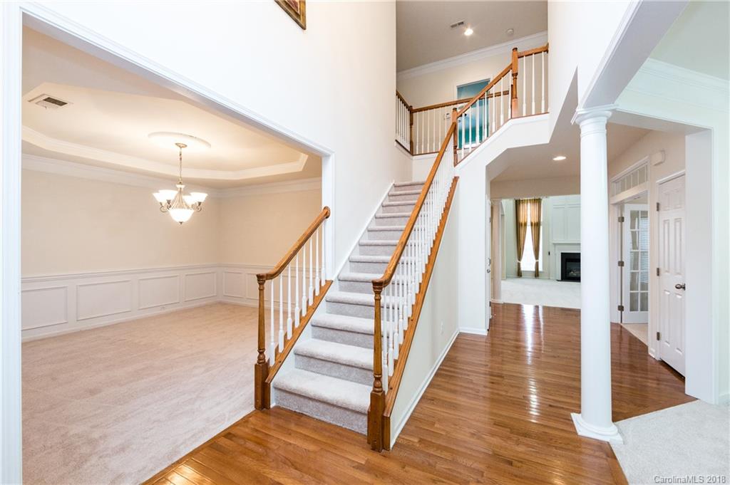 7810 Greylock Ridge Road Matthews, NC 28105 - Photo 4 of 31 a view of staircase with lots of frames on wall and wooden floor