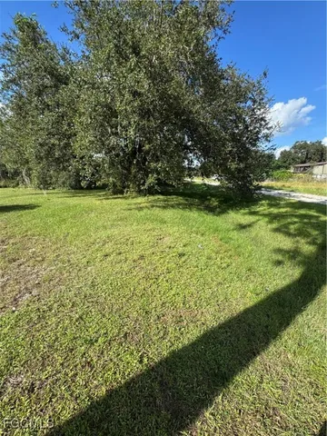 a view of a field with an trees in the background
