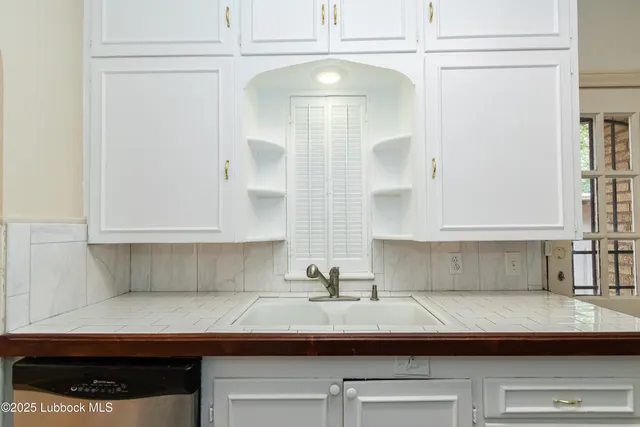 a view of an empty room with window and chandelier fan